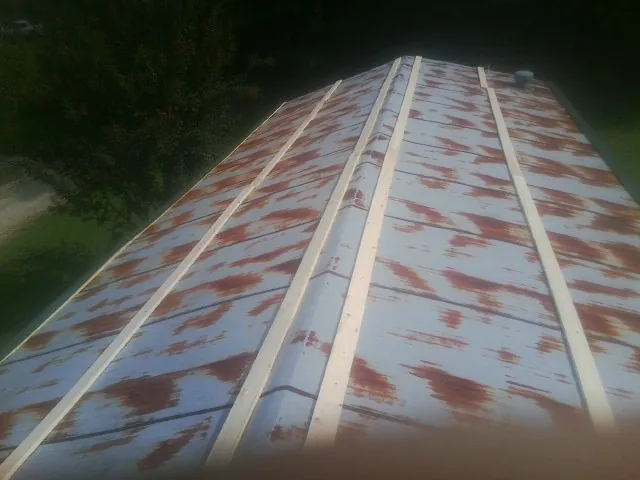 Rusted metal roof panels with new wood purlins before replacement — Storm Damage Roof Repair in Lakewood by Roofing Brothers